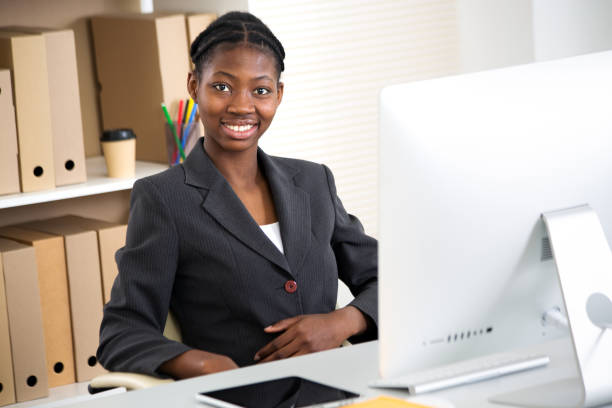 Portrait of pretty africanamerican business woman looking at camera at workplace in an office